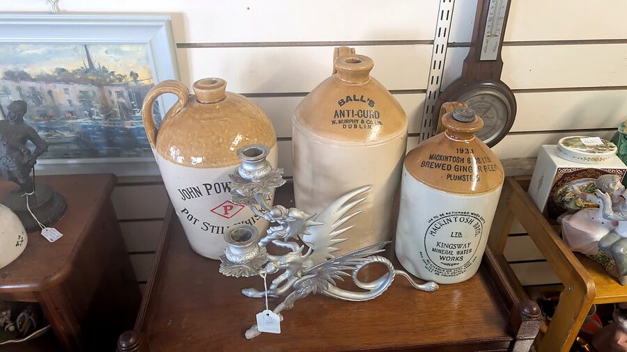 Antique stoneware jugs and a silver dragon candlestick at Tom's Curios